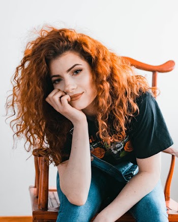 Woman Sitting On Chair And Putting Right Hand On Her Cheek