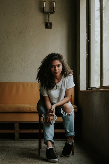 Woman Sitting on Chair Beside Window