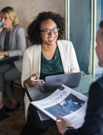 Woman Sitting on Chair Facing Man Holding Newspaper