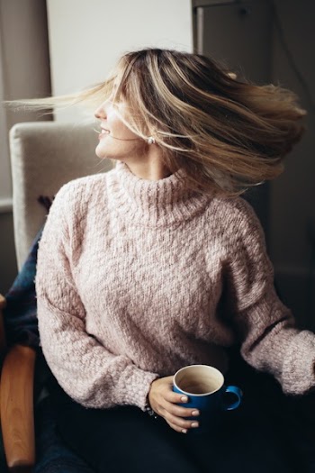 Woman Sitting On Chair Holding Blue Mug