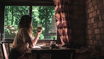 Woman Sitting on Chair Holding Clear Glass Cup
