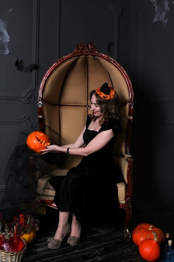 Woman Sitting on Chair Holding Jack-o-lantern
