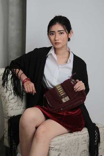 Woman Sitting on Chair Holding Maroon Bag