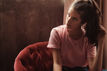 Woman Sitting on Chair Touching Hair and Looking Her Right Side