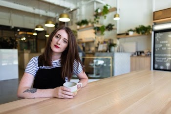 woman sitting on chair while holding mug