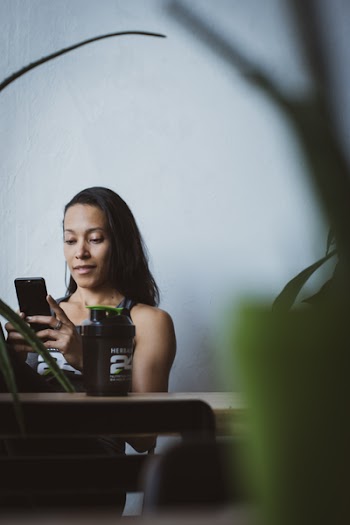 Woman Sitting on Chair While Holding Smartphone