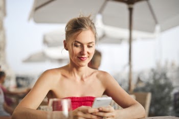 Woman Sitting on Chair While Holding Smartphone