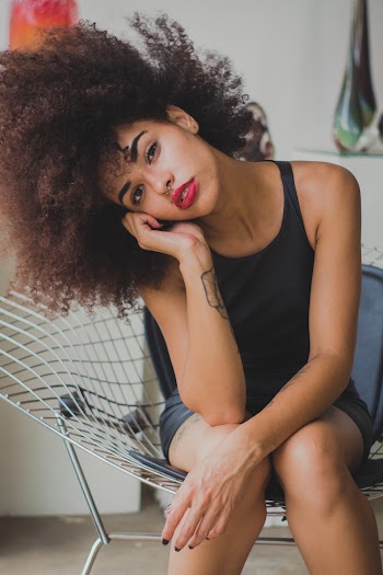 Woman Sitting On Chair While Leaning Face On Her Right Hand