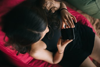 Woman Sitting on Chair While Using Smartphone