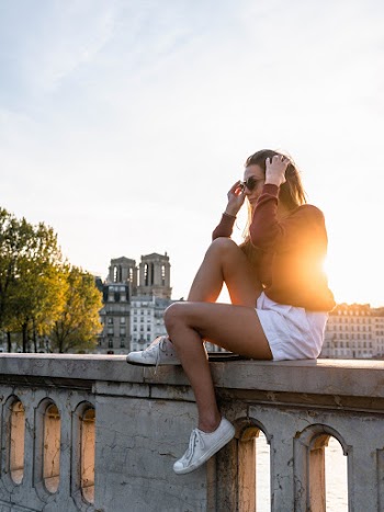 Woman Sitting on Concrete Ballister during Sunset