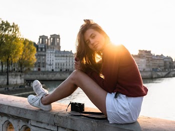 Woman Sitting on Concrete Bridge Near Ocean