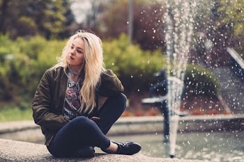 Woman Sitting on Concrete Fountain