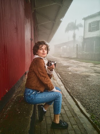 Woman Sitting on Concrete Holding A Camera