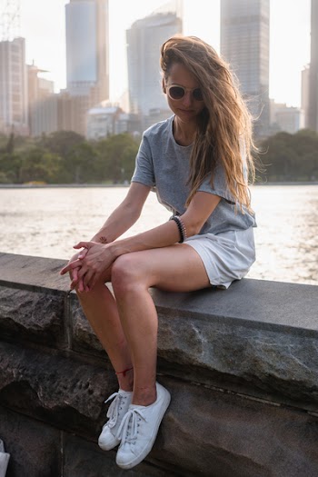 Woman Sitting on Concrete Slab Beside Body of Water