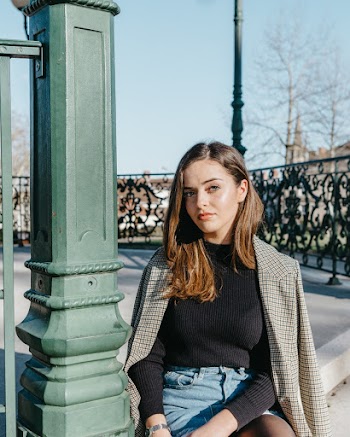 Woman Sitting on Concrete Stairs Beside Green Concrete Post