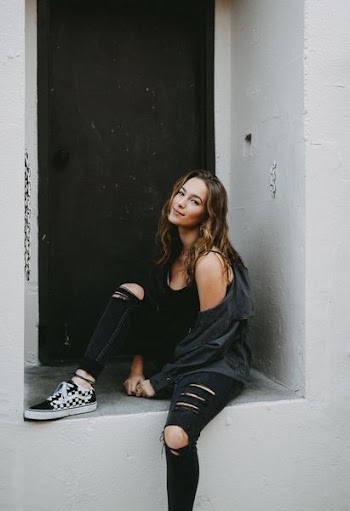 woman sitting on concrete wall with door