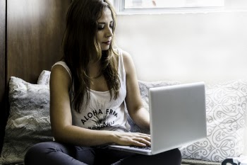 Woman Sitting on Couch With Macbook Pro on Lap