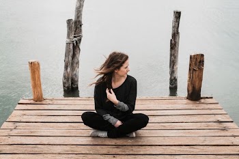 woman sitting on dock during daytime