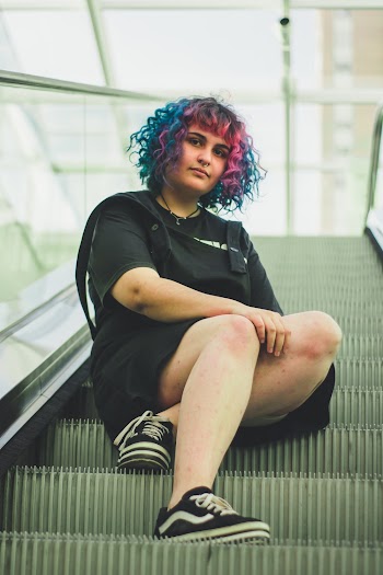 Woman Sitting on Escalator