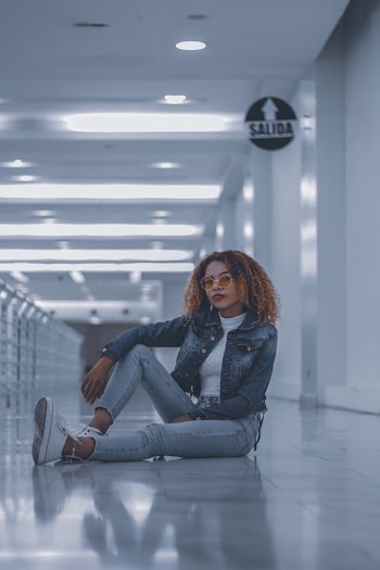 Woman Sitting on Floor and Raising Her Right Foot
