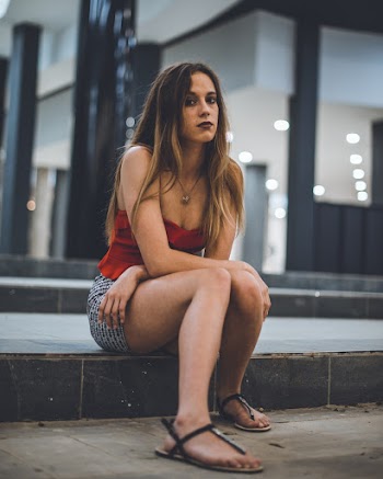 Woman Sitting on Floor Near Building