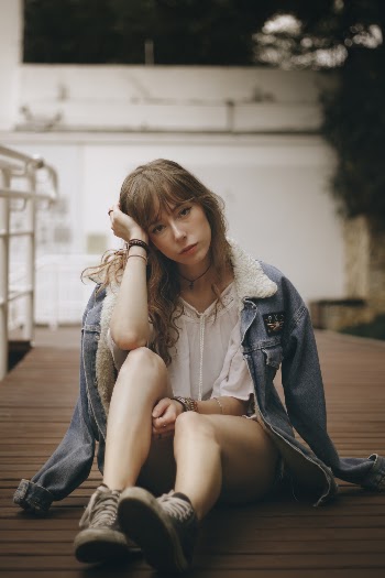 Woman Sitting On Floor With Blue Denim Jacket On Her Shoulders