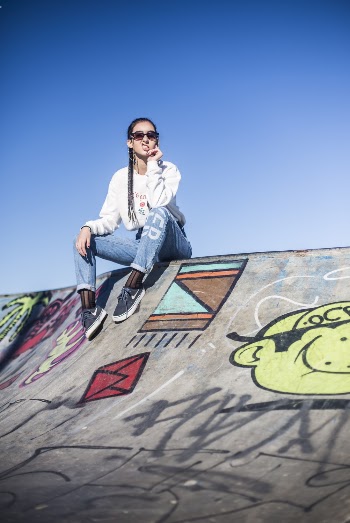 Woman Sitting on Graffiti Painted Skate Park
