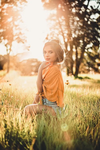 Woman Sitting on Grass Field