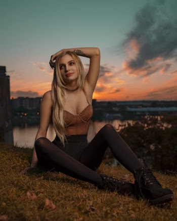 Woman Sitting on Grass Field Near During Golden Hour
