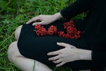 Woman Sitting on Grass With Red Fruits on Lap
