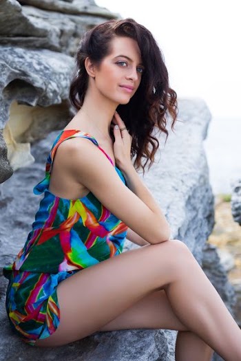 woman sitting on gray boulder during daytime