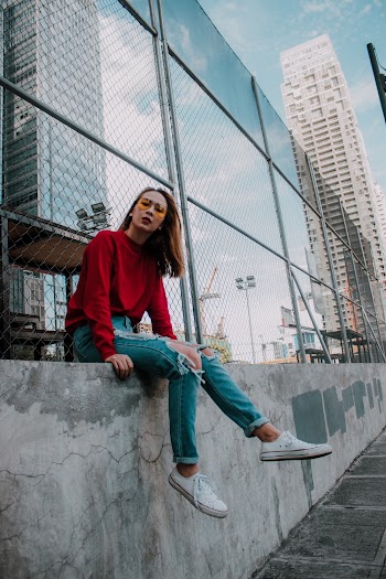 Woman Sitting on Gray Concrete Fence