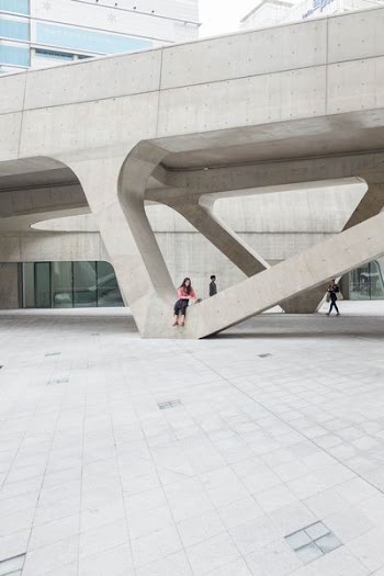 woman sitting on gray concrete formation during daytime