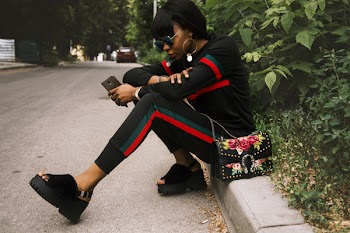 Woman Sitting on Gray Concrete Sidewalk Taken