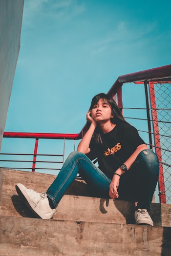 Woman Sitting on Gray Concrete Stairs Outdoors