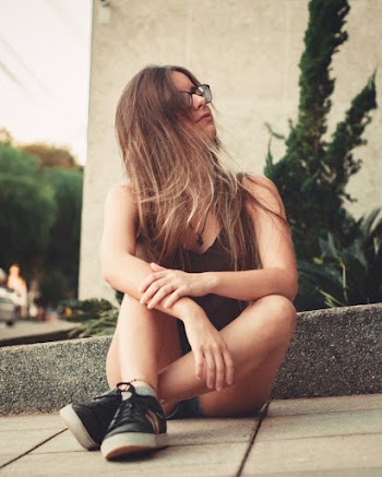 Woman Sitting on Gray Pathway