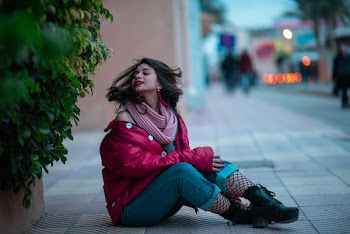 Woman Sitting on Gray Road