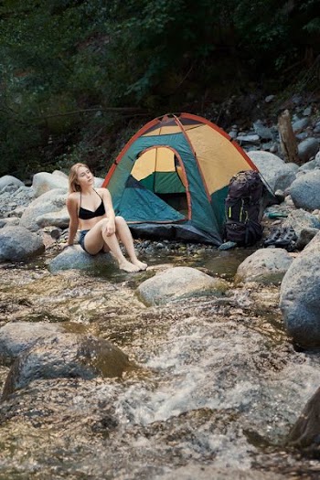 woman sitting on gray rock during daytime