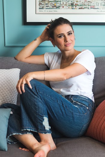 Woman Sitting on Gray Sofa Beside Green Wall