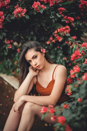 Woman Sitting on Ground Beside Flowers