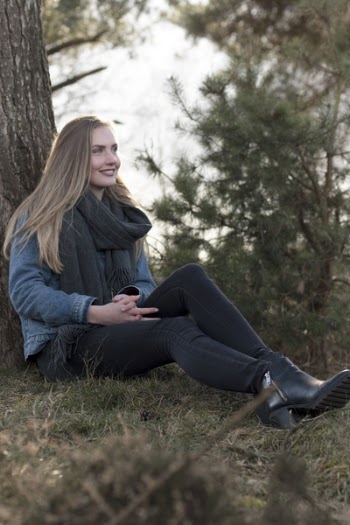 Woman Sitting on Ground Leaning Against Tree