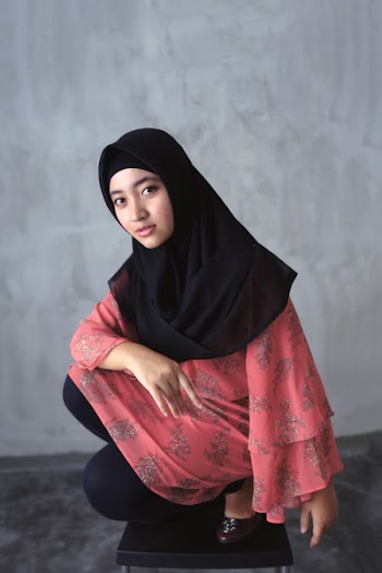 Woman Sitting on Ground Near Gray Concrete Wall