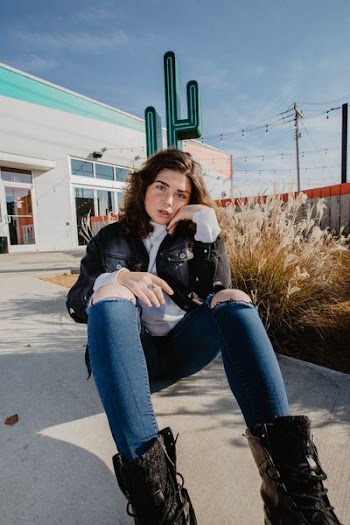 woman sitting on ground near store