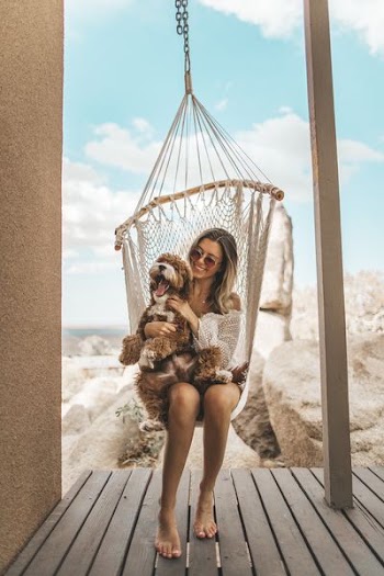 woman sitting on hammock with plush toy