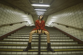 Woman Sitting on Handrail With Both Hand on Front
