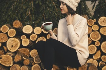 Woman Sitting On Logs While Holding a Drink