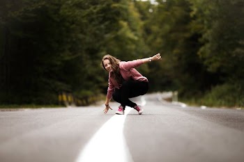 woman sitting on middle of the road