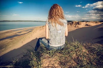 woman sitting on mountain edge