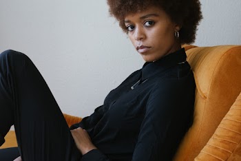 Woman Sitting on Orange Sofa