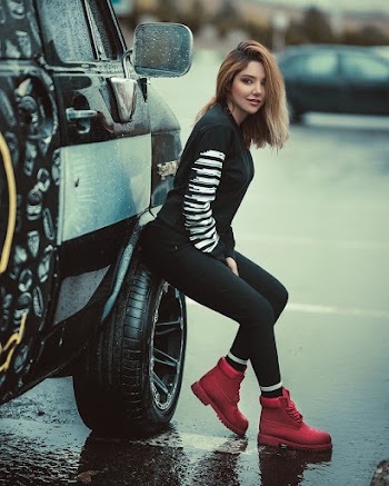 Woman Sitting on Parked Vehicle Front Tire